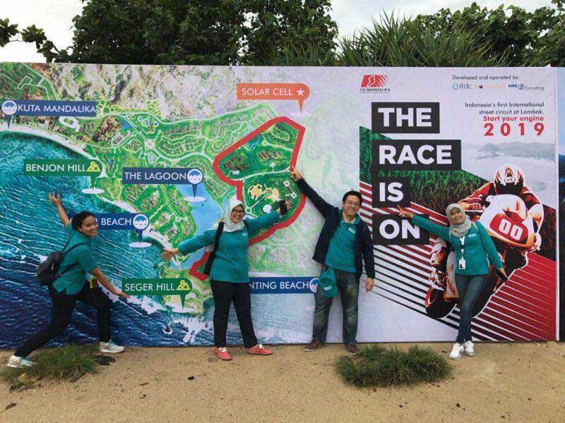 ITDC employees pose in front of Mandalika Race Is On signage heralding new Moto GP race track